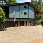 Exterior house painting in Greenville SC - sage green board-and-batten siding with black trim and brick base by Verdeja Painting
