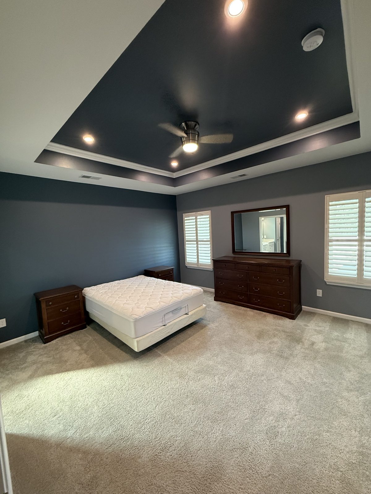 Master bedroom with navy painted tray ceiling and accent wall by Verdeja Painting & Remodeling in Greenville, SC