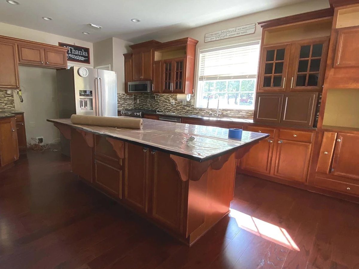 Orange-toned wood kitchen cabinets and island before painting – Greenville, SC