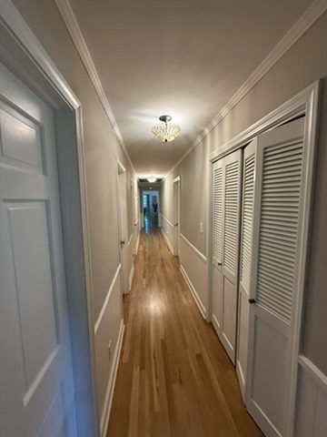 Hallway in a Greer, SC home with freshly painted walls, crown molding, trim and louvered closet doors