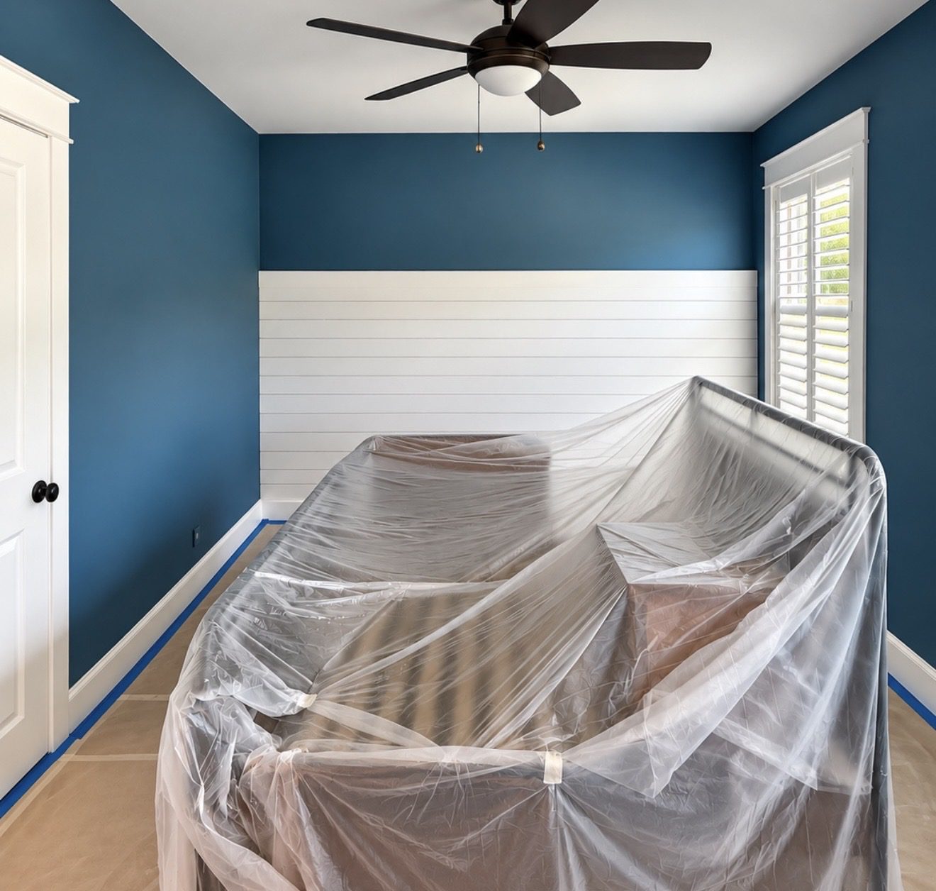 Bedroom with deep blue walls and a white shiplap accent wall, interior painting by Verdeja Painting